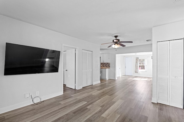 unfurnished living room with ceiling fan and wood-type flooring