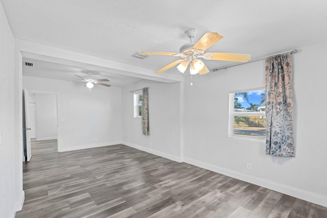 spare room featuring a wealth of natural light, ceiling fan, and wood-type flooring