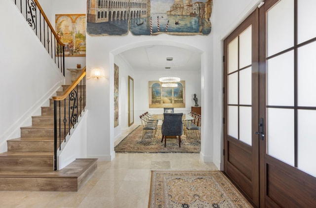 foyer featuring french doors and crown molding