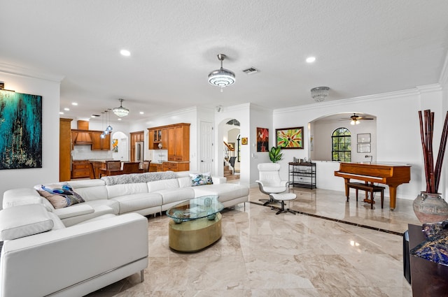 living room with ceiling fan, ornamental molding, and a textured ceiling