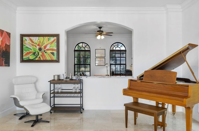 living area with ceiling fan and ornamental molding