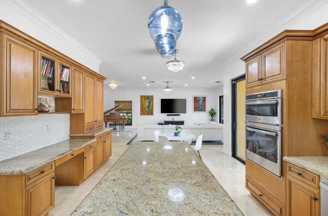 kitchen featuring appliances with stainless steel finishes, decorative light fixtures, built in desk, and light stone countertops