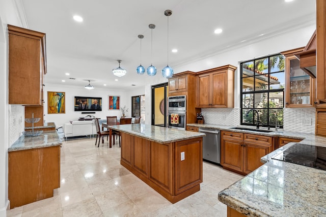 kitchen with appliances with stainless steel finishes, hanging light fixtures, light stone countertops, a center island, and sink