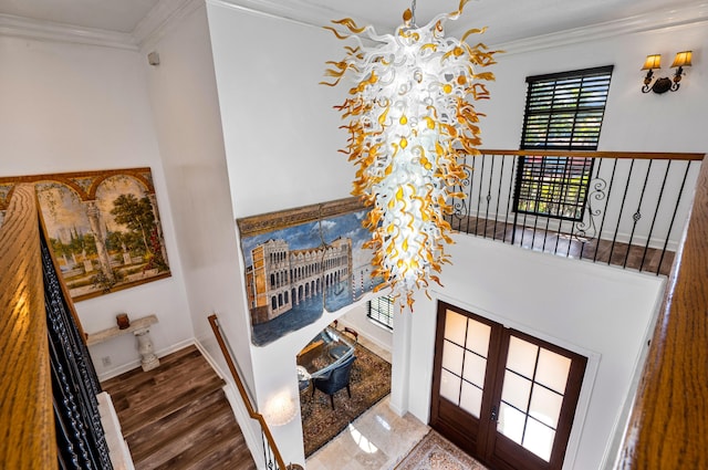 stairs with hardwood / wood-style flooring, ornamental molding, and a chandelier