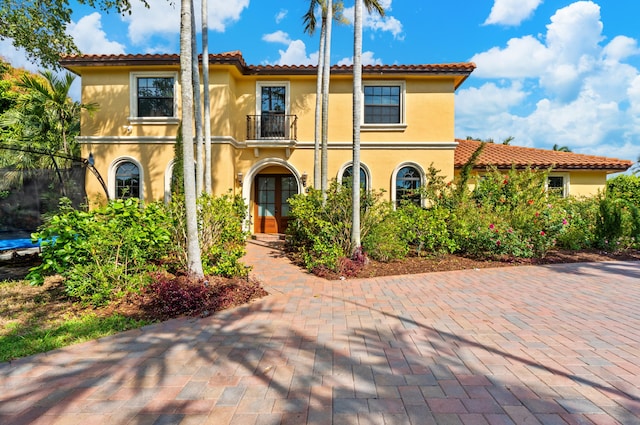 mediterranean / spanish home featuring french doors and a balcony