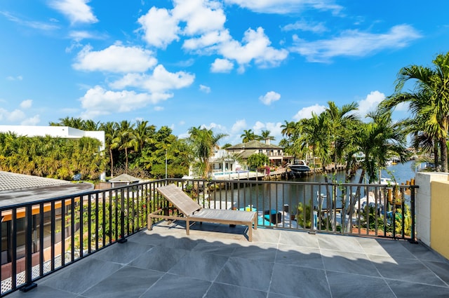 view of patio featuring a water view and a balcony