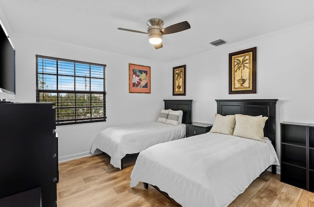 bedroom featuring ceiling fan, light hardwood / wood-style flooring, and crown molding