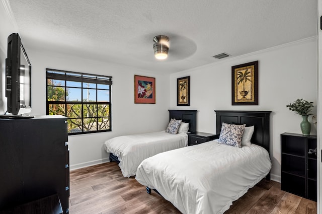 bedroom featuring crown molding, hardwood / wood-style floors, ceiling fan, and a textured ceiling