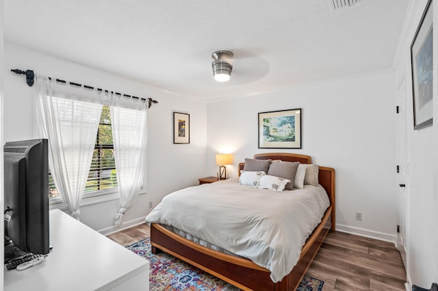 bedroom featuring dark hardwood / wood-style floors and a textured ceiling