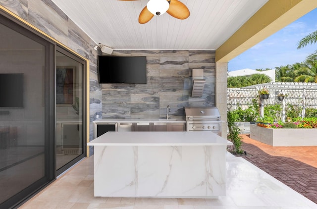 view of patio with ceiling fan, sink, exterior kitchen, and a grill