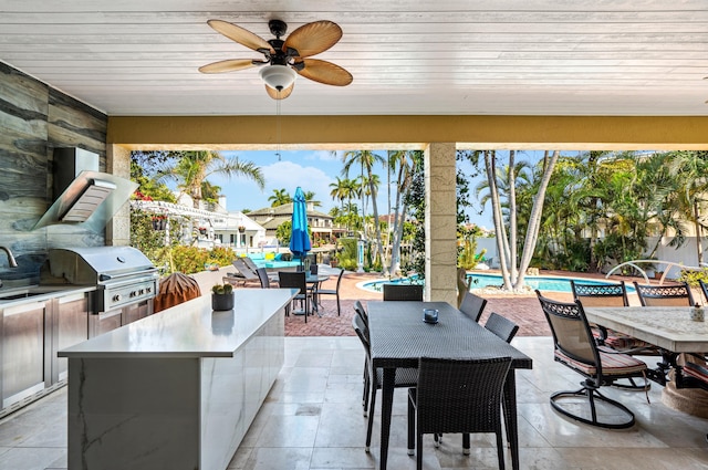 view of patio featuring grilling area, ceiling fan, and exterior kitchen