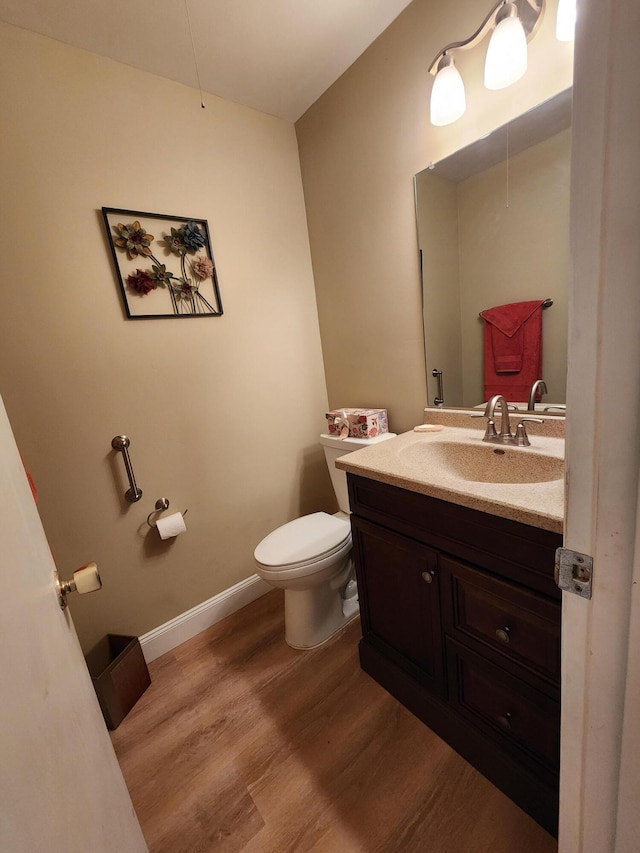 bathroom with vanity, wood-type flooring, and toilet