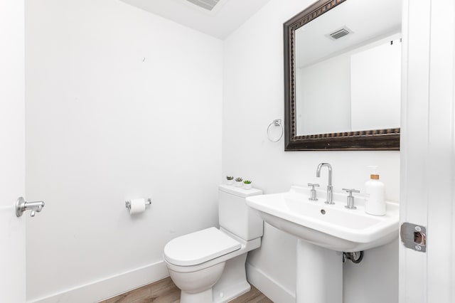 bathroom featuring hardwood / wood-style flooring, toilet, and sink