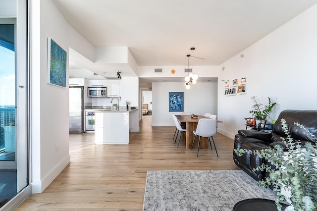 dining space with light wood-type flooring and sink