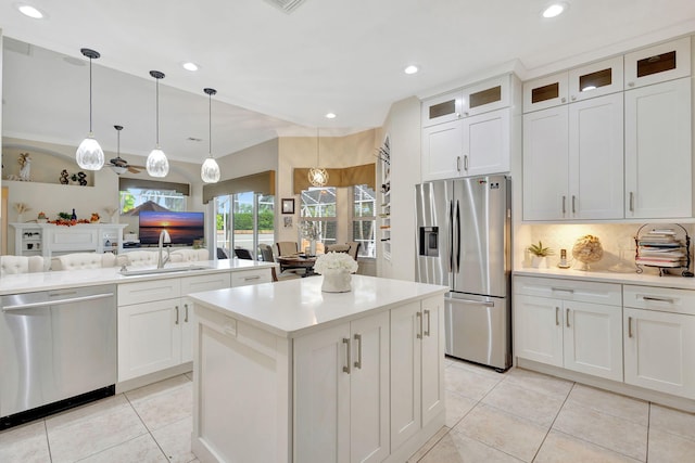 kitchen featuring white cabinets, decorative light fixtures, a kitchen island, and appliances with stainless steel finishes