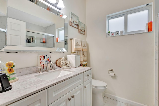 bathroom featuring toilet, vanity, tile patterned floors, and a shower with door