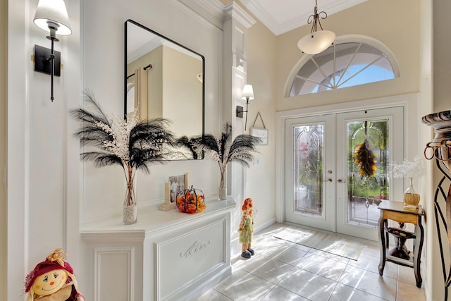 entrance foyer featuring tile patterned floors, crown molding, and french doors