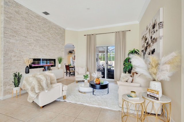 tiled living room featuring a stone fireplace and ornamental molding