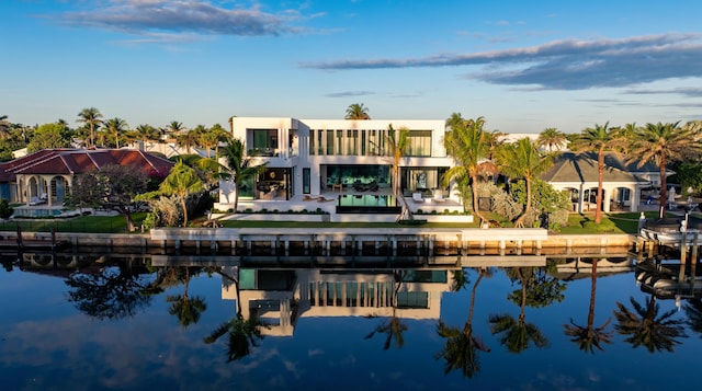 rear view of house featuring a water view and stucco siding