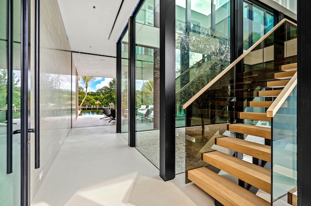 stairway with a wall of windows and finished concrete floors