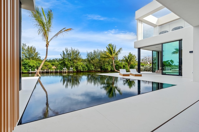 view of swimming pool with a patio and a water view