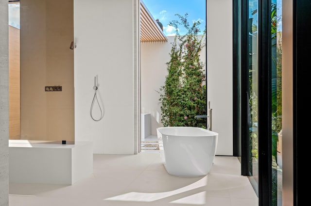 bathroom with a shower, tile patterned flooring, and a freestanding tub