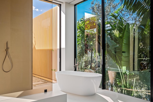 bathroom featuring expansive windows and a soaking tub