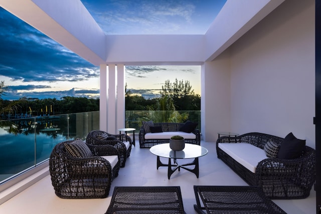 patio terrace at dusk featuring a balcony and an outdoor living space