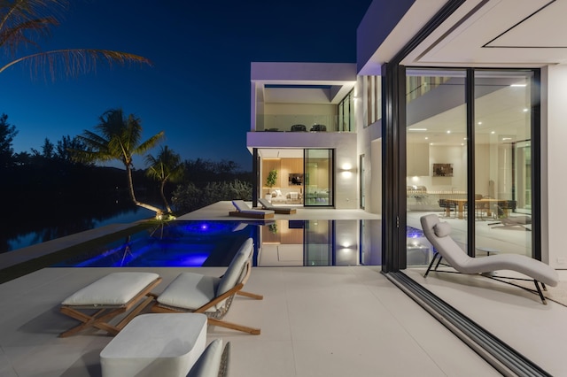 pool at night featuring a hot tub