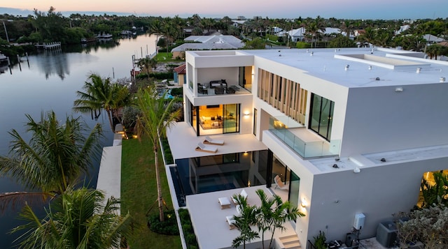 aerial view at dusk featuring a water view