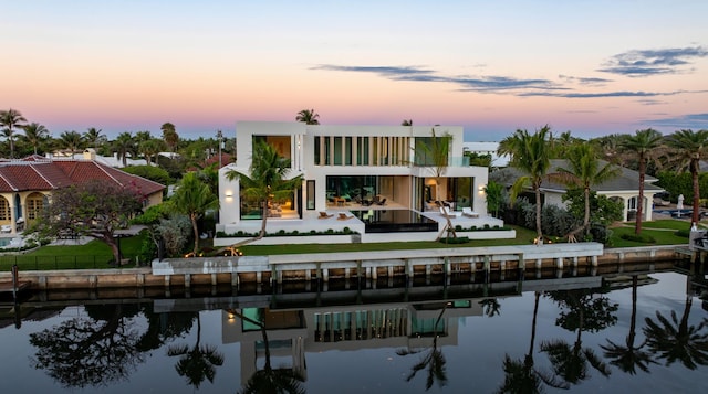 rear view of property featuring a water view and stucco siding