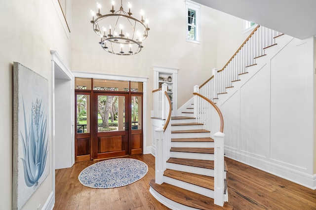 foyer entrance with hardwood / wood-style flooring and a towering ceiling