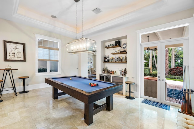 game room featuring ornamental molding, pool table, a raised ceiling, bar area, and french doors