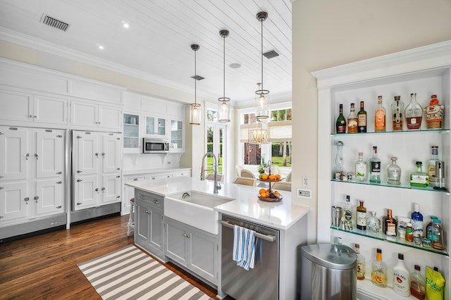 kitchen with dark hardwood / wood-style flooring, stainless steel appliances, sink, white cabinetry, and hanging light fixtures