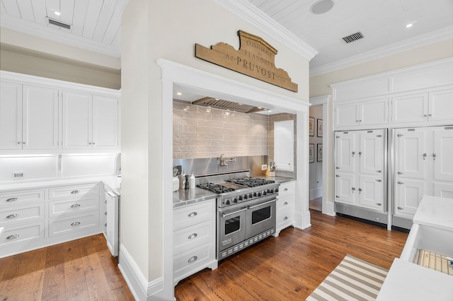 kitchen with crown molding, backsplash, white cabinets, dark hardwood / wood-style flooring, and range with two ovens