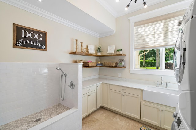 bathroom with ornamental molding, vanity, and a tile shower