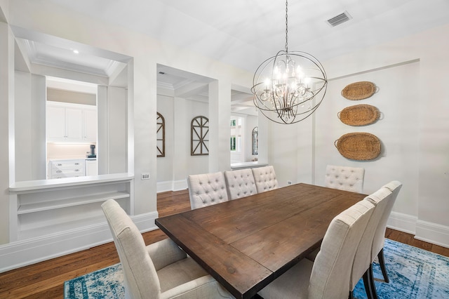 dining space with ornamental molding, dark wood-type flooring, and a notable chandelier