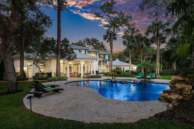 pool at dusk with a patio