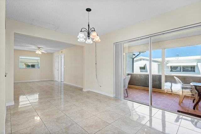 unfurnished room featuring ceiling fan with notable chandelier, light tile patterned floors, and a textured ceiling