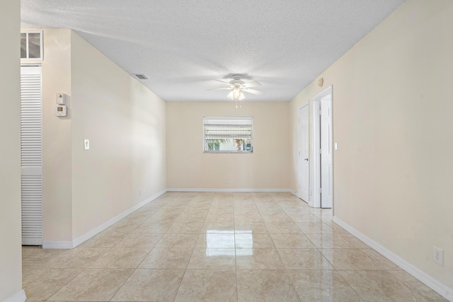 unfurnished room featuring ceiling fan, light tile patterned flooring, and a textured ceiling