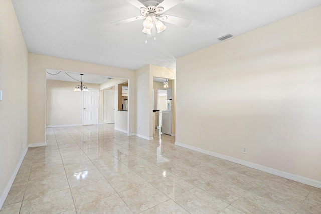 empty room with ceiling fan with notable chandelier