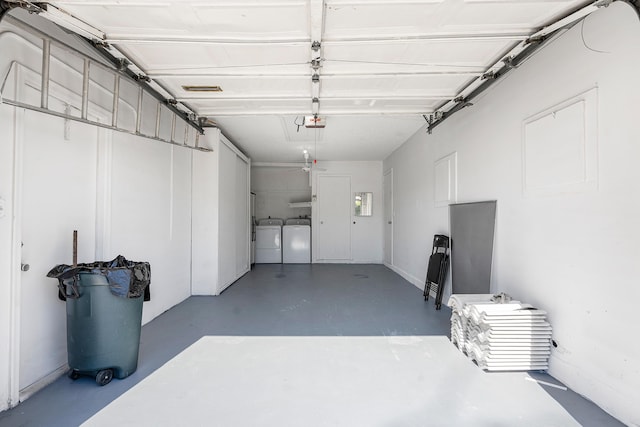 garage with a garage door opener and independent washer and dryer