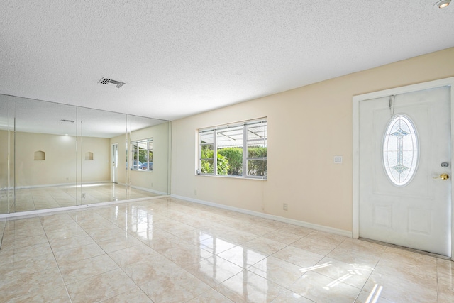 entrance foyer featuring light tile patterned floors and a textured ceiling