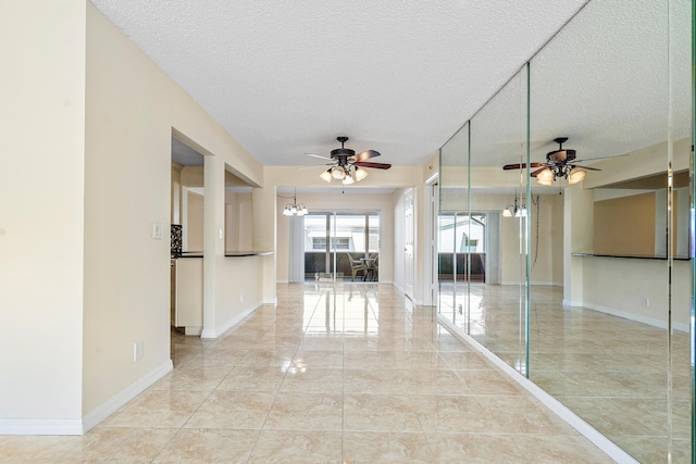 interior space with ceiling fan with notable chandelier and a textured ceiling