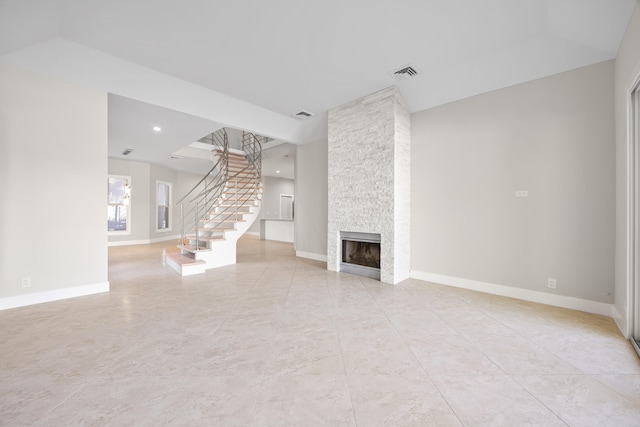 unfurnished living room with light tile patterned floors and a stone fireplace