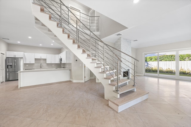 stairway with tile patterned flooring and sink