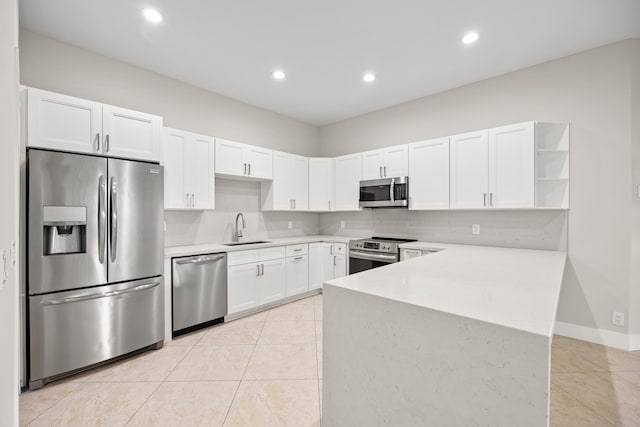 kitchen with sink, white cabinets, stainless steel appliances, and light tile patterned floors