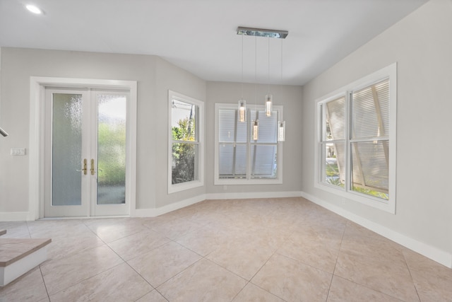 unfurnished dining area with french doors, light tile patterned flooring, and a notable chandelier