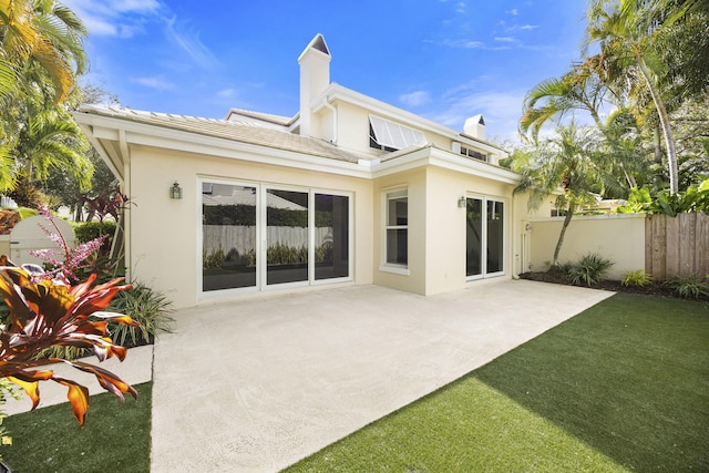 rear view of property featuring a yard and a patio