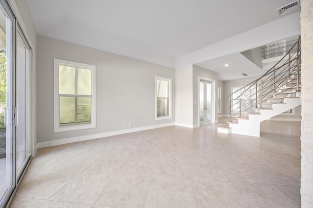 empty room featuring light tile patterned flooring and a healthy amount of sunlight